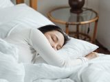 young woman sleeping in comfy bed